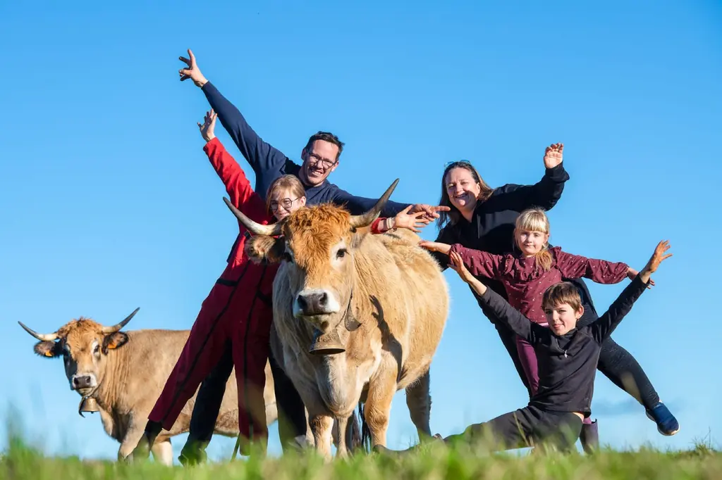 La famille Gras avec leurs vaches Aubrac dans les prairies de Cézens, Cantal
